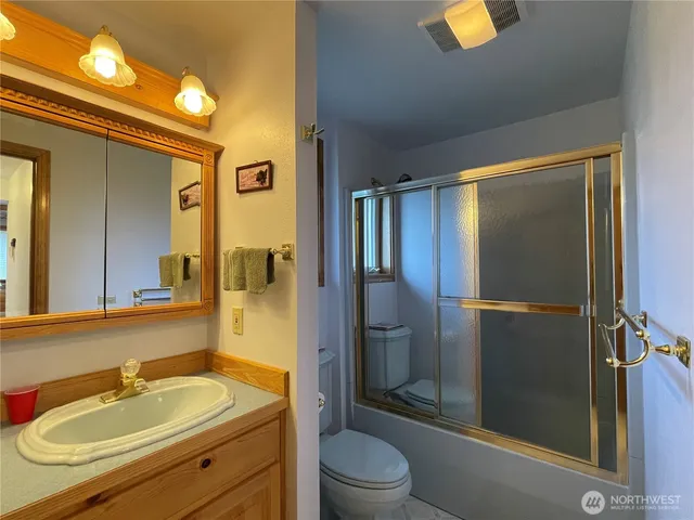 a bathroom with a sink a toilet and shower