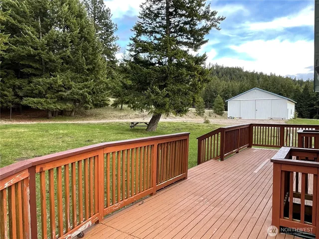 a balcony with wooden floor and yard in the back
