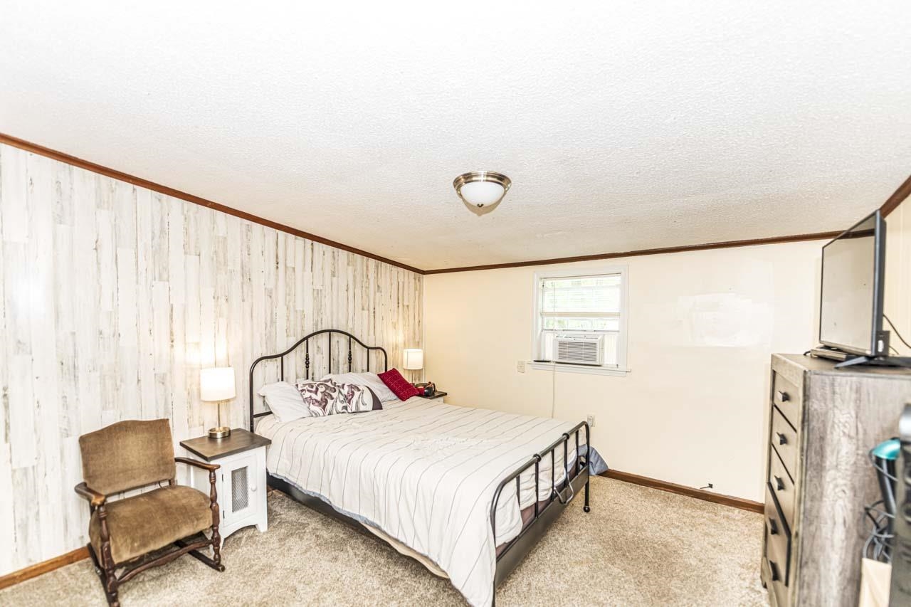 827 Sanford Road Covington, TN 38019 - Photo 17 of 25 a bedroom with a bed next to a window with chair and table