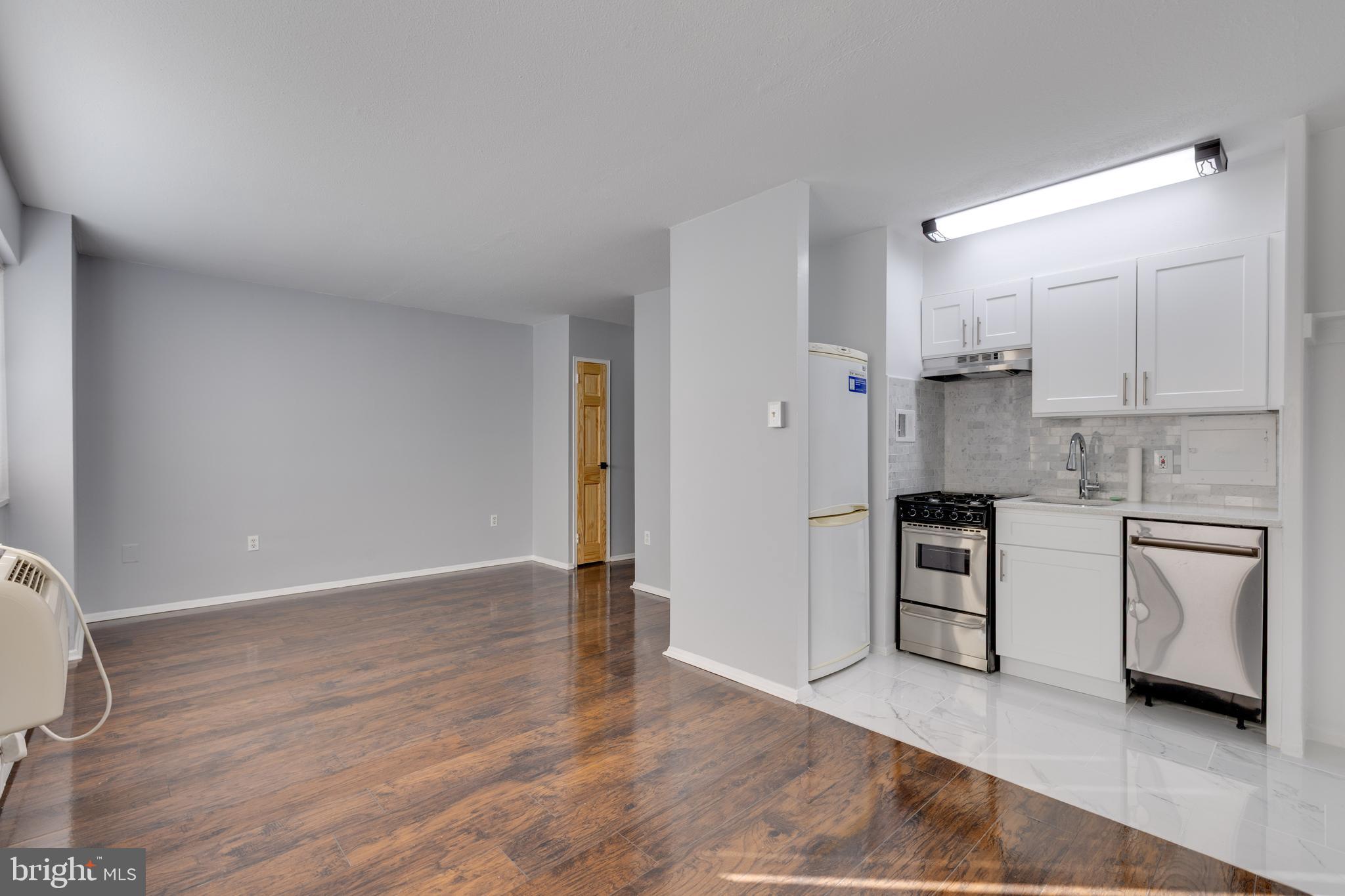 2101-17 Chestnut Street, Unit 705 Philadelphia, PA 19103 - Photo 1 of 10 a kitchen with a refrigerator and white cabinets