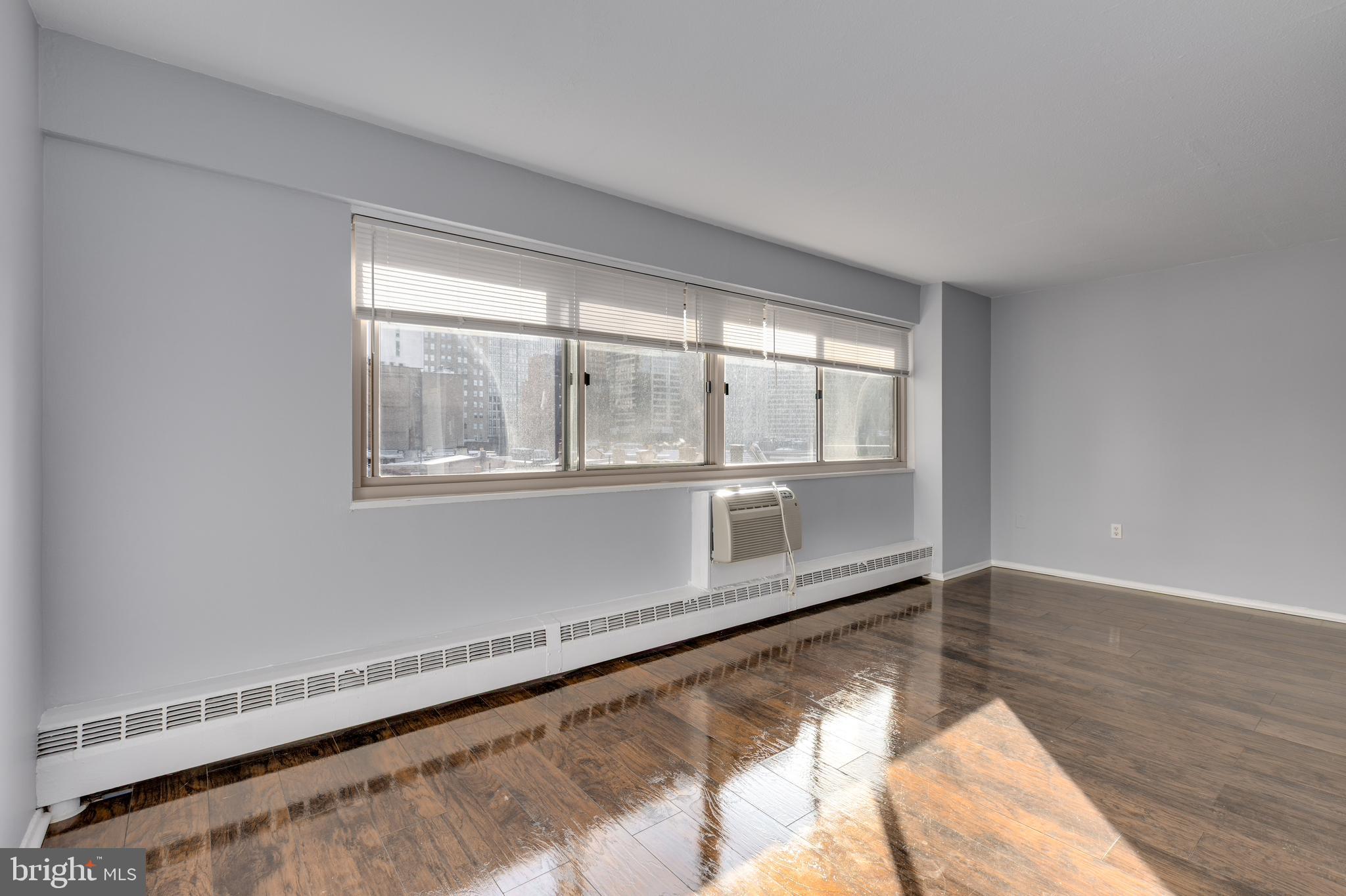 2101-17 Chestnut Street, Unit 705 Philadelphia, PA 19103 - Photo 2 of 10 a view of an empty room with wooden floor and a window
