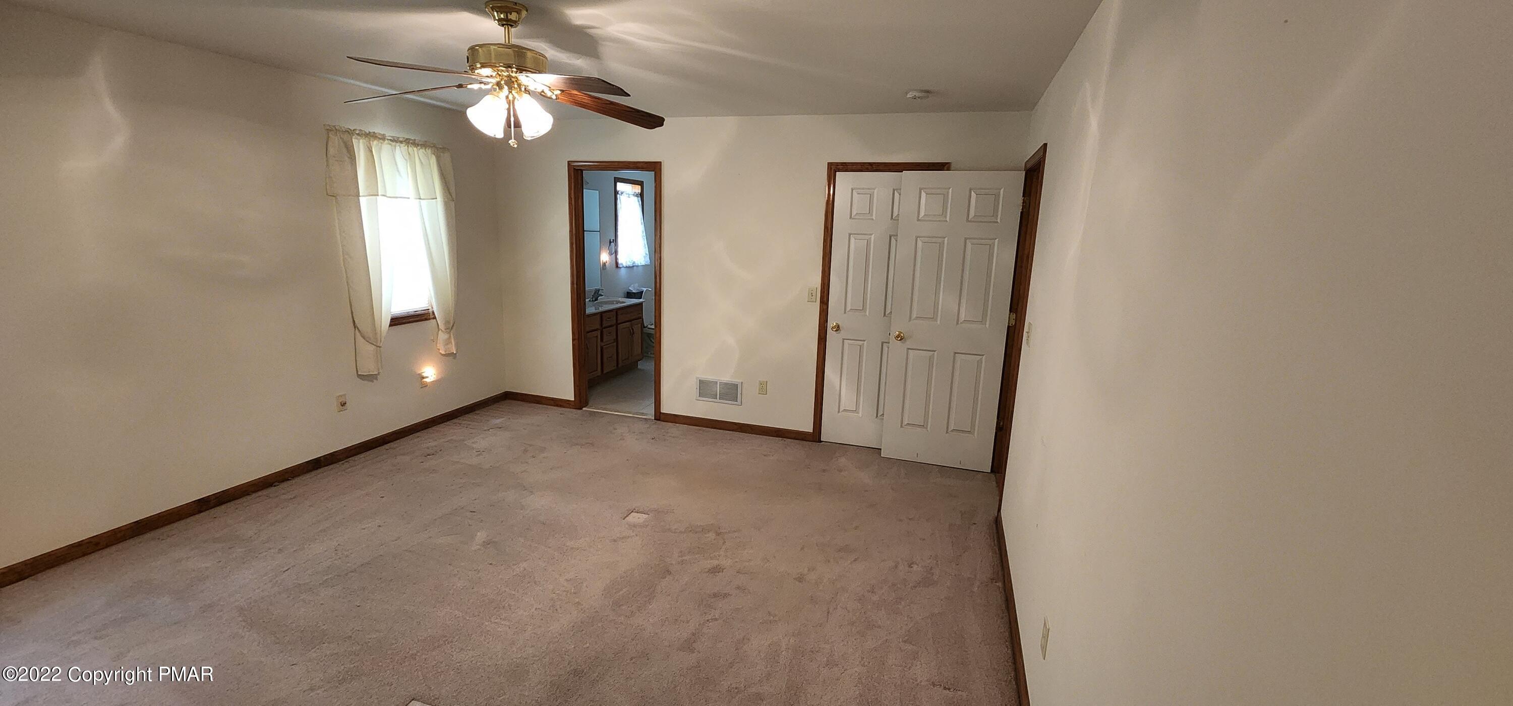 203 Sutton Place Pocono Summit, PA 18346 - Photo 12 of 22 an empty room with windows and fan