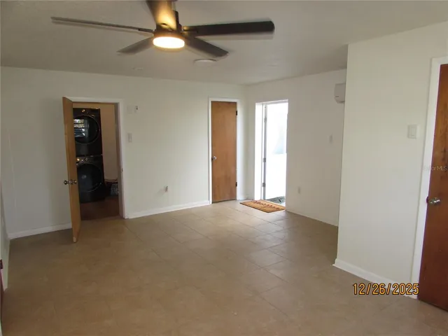 an empty room with closet and a chandelier fan