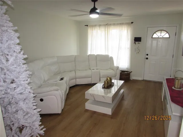 a living room with furniture and a wooden floor