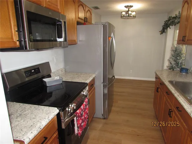 a kitchen with stainless steel appliances granite countertop a sink stove and refrigerator