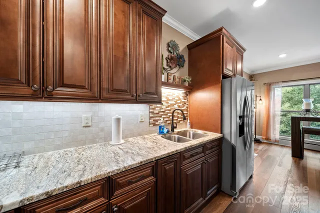a kitchen with stainless steel appliances granite countertop a sink and a refrigerator