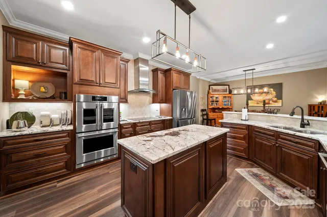 a kitchen with stainless steel appliances granite countertop wooden cabinets a stove top oven a sink and dishwasher