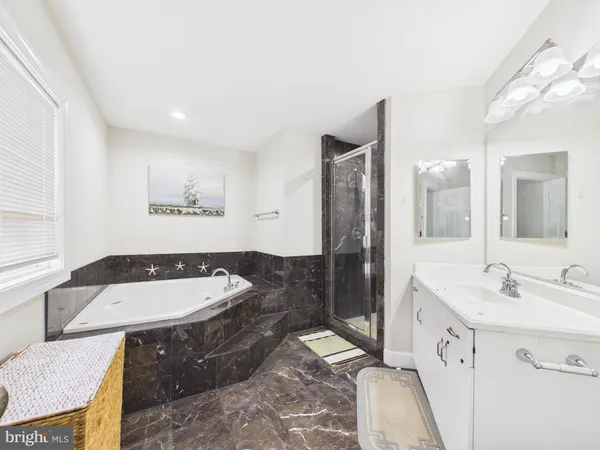 a spacious bathroom with a double vanity sink a mirror and a bathtub