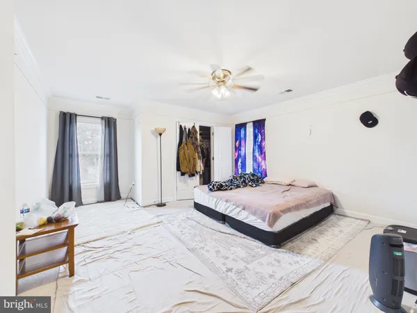a spacious bedroom with a bed and a chandelier