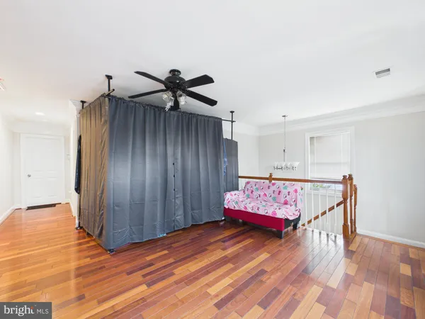a living room with a bed and wooden floor