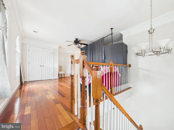 a view of a hallway with wooden floor and stairs