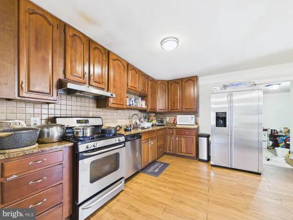 a kitchen with granite countertop wooden cabinets and stainless steel appliances