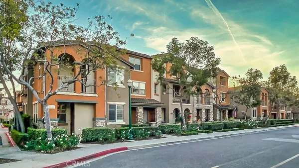 a view of a patio with a table and chairs under an umbrella with a small garden