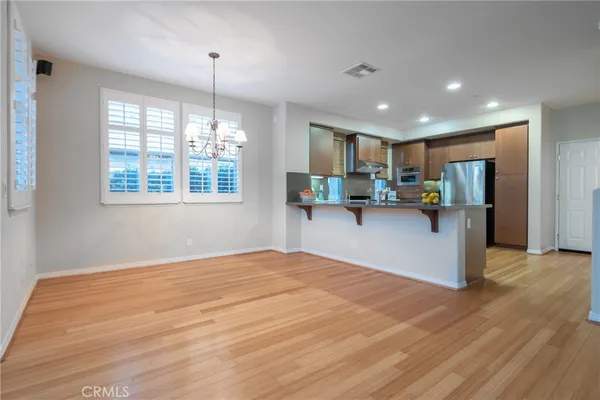 a kitchen with stainless steel appliances granite countertop a refrigerator and a wooden floors