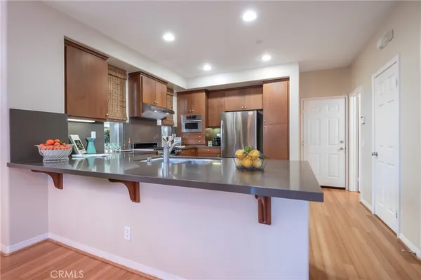 a kitchen with stainless steel appliances granite countertop a sink refrigerator and microwave