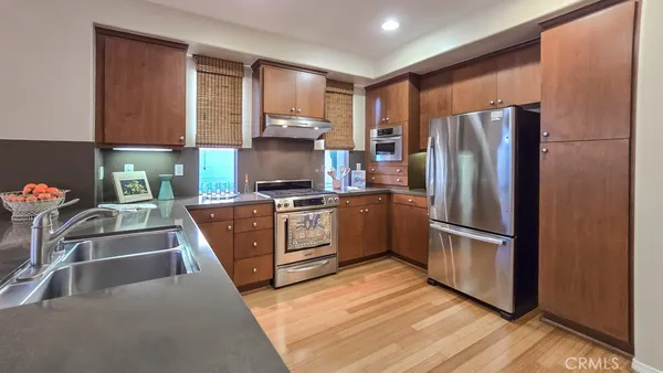 a kitchen with granite countertop a refrigerator and a sink