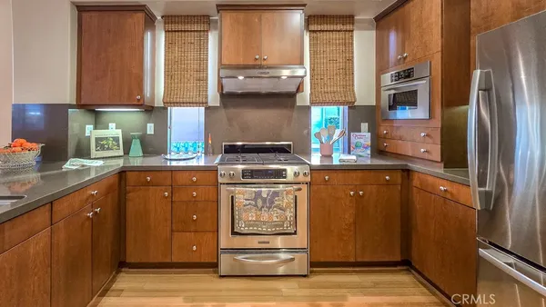 a kitchen with stainless steel appliances granite countertop a stove a sink and a refrigerator