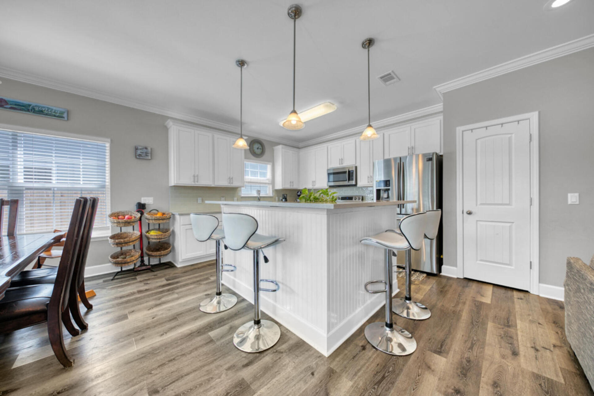 507 Johnson Street Valparaiso, FL 32580 - Photo 13 of 40 a kitchen with stainless steel appliances granite countertop a stove a refrigerator a kitchen island a dining table and chairs with wooden floor