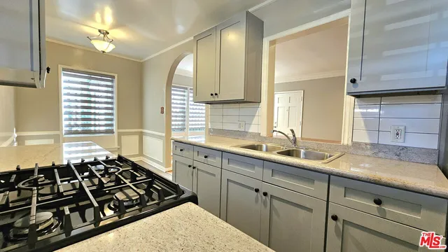 a kitchen with sink a stove and a window