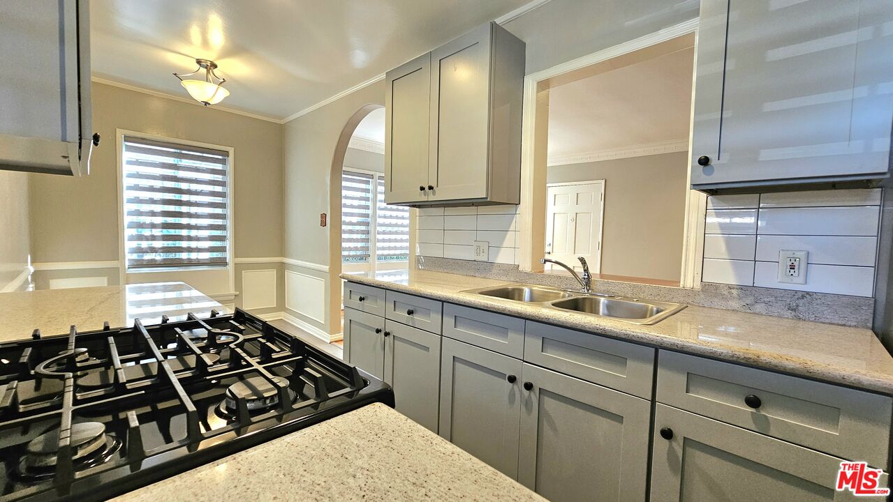 a kitchen with sink a stove and a window