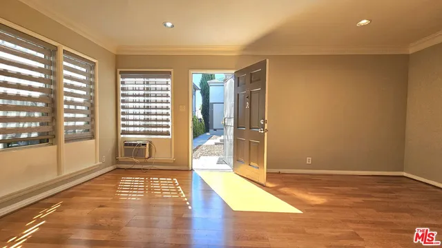 a view of a big room with wooden floor and windows