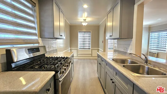 a kitchen with stainless steel appliances a sink stove and cabinets