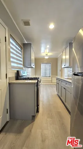 a kitchen with stainless steel appliances granite countertop a sink a stove and a refrigerator