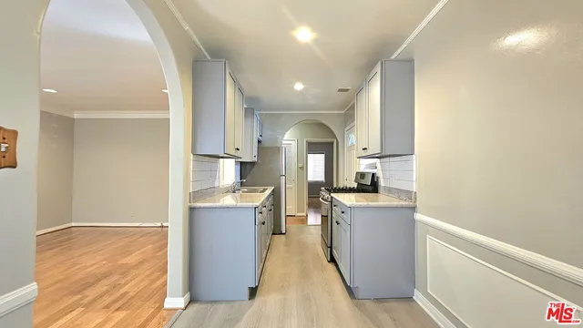 a view of a kitchen with a sink and wooden floor