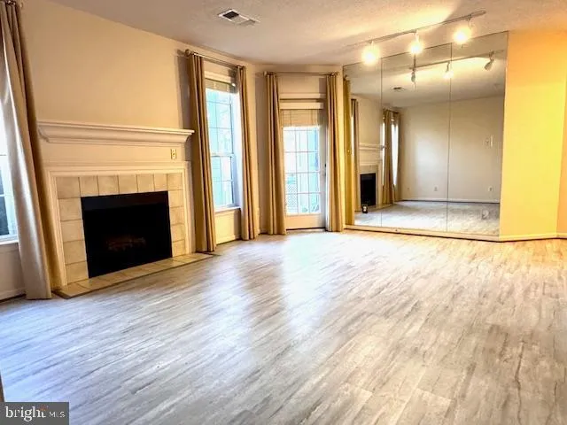 a view of empty room with wooden floor and fireplace