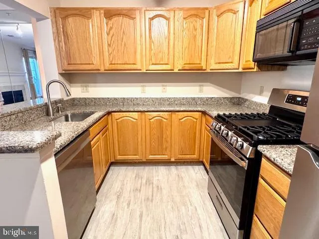 a kitchen with granite countertop white cabinets and stainless steel appliances