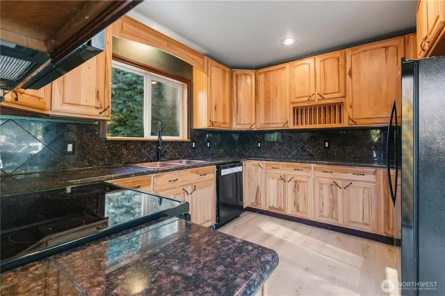 a kitchen with granite countertop a stove a sink and a microwave