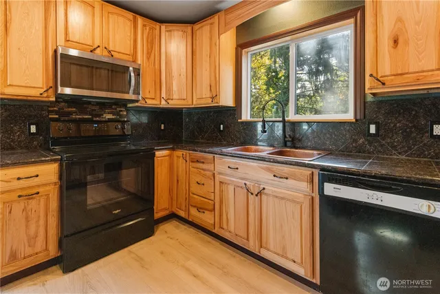 a kitchen with stainless steel appliances granite countertop a stove a sink and a microwave