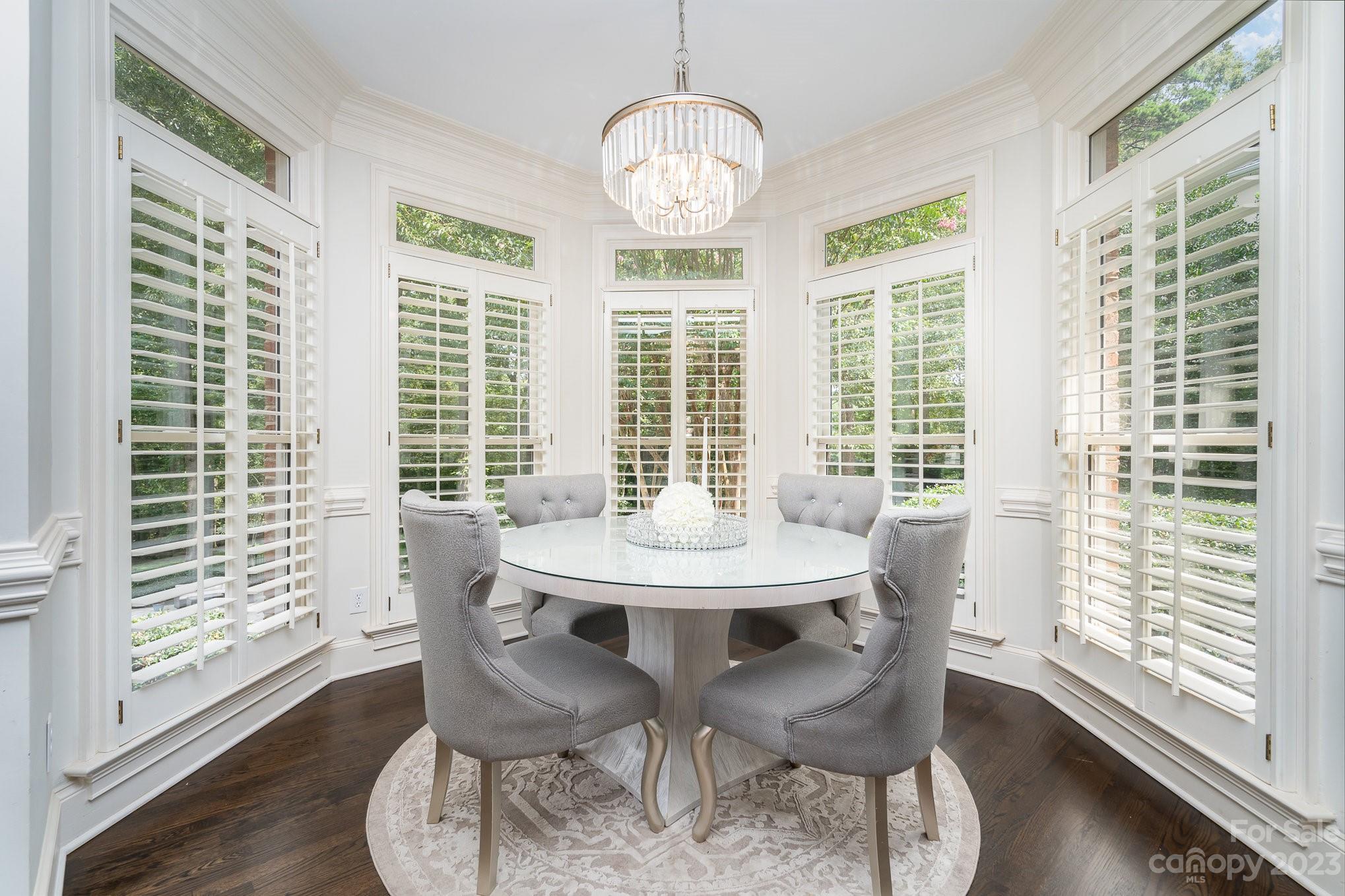 6535 Seton House Lane Charlotte, NC 28277 - Photo 13 of 48 a view of a dining room with furniture large windows and wooden floor