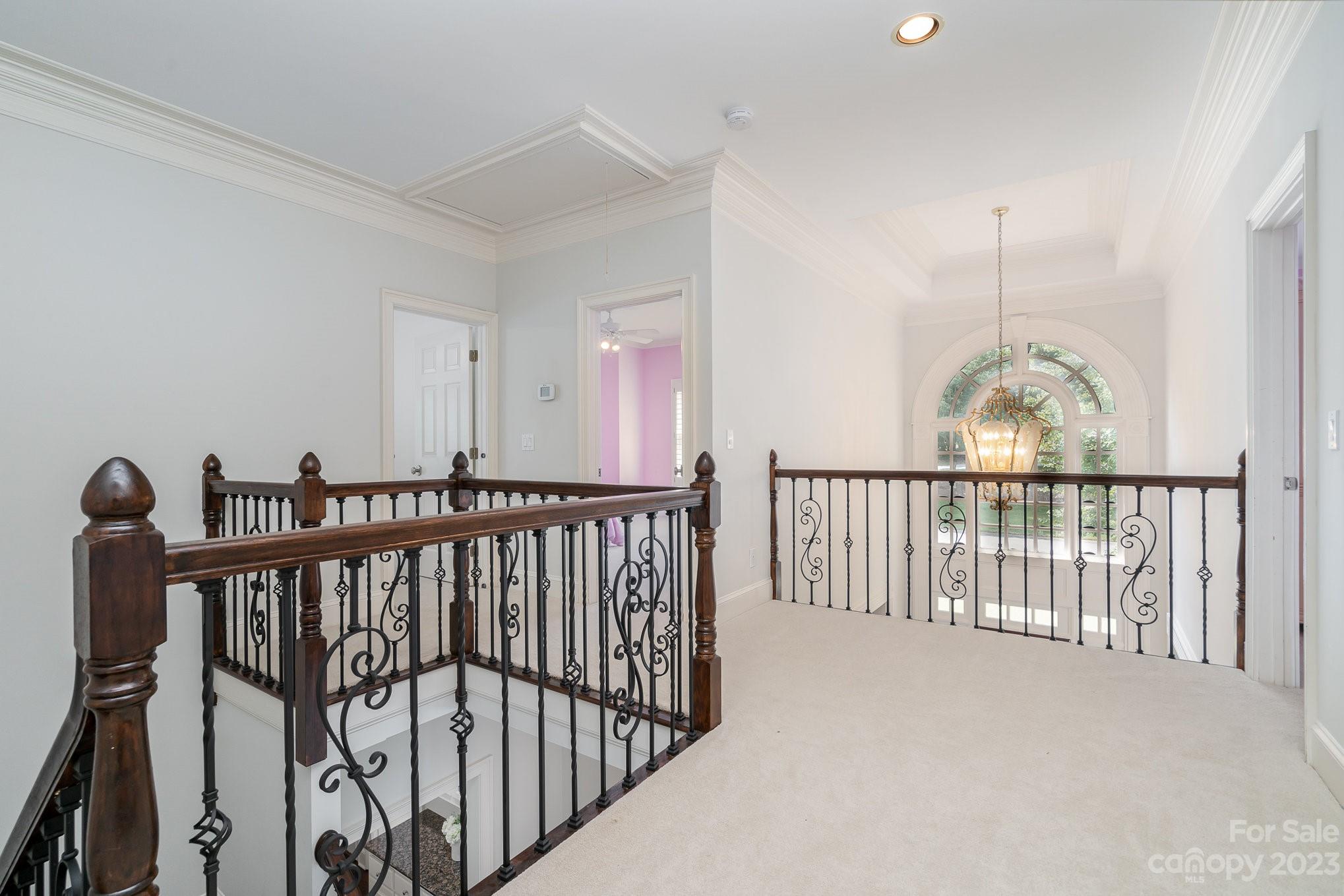 6535 Seton House Lane Charlotte, NC 28277 - Photo 22 of 48 a view of staircase with railing and a chandelier fan