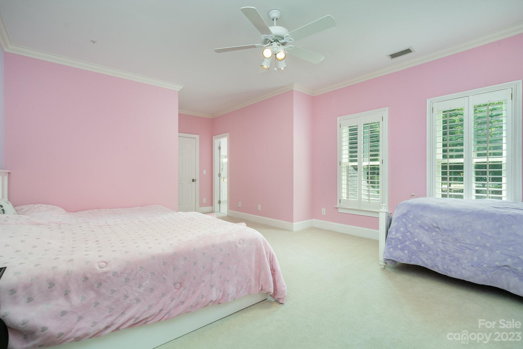 6535 Seton House Lane Charlotte, NC 28277 - Photo 25 of 48 a spacious bedroom with a bed chandelier and a window