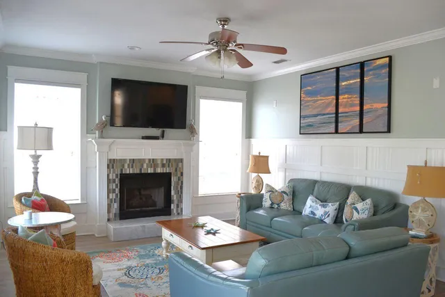 a living room with furniture a flat screen tv and a fireplace