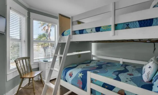 a bedroom with a bunk bed and a window