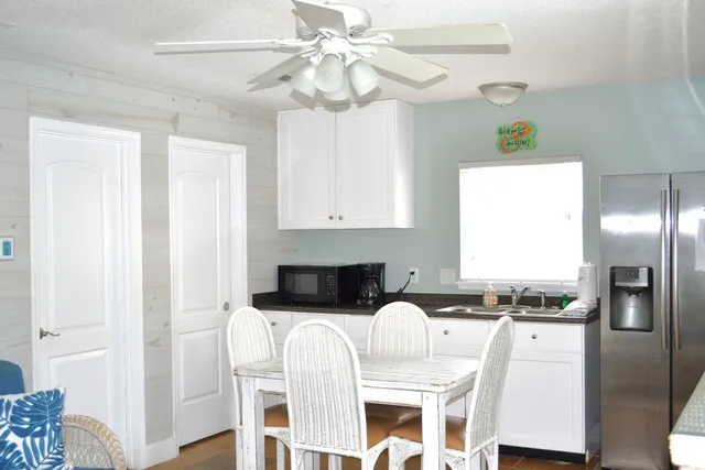 a kitchen with stainless steel appliances granite countertop a refrigerator a stove a sink dishwasher and white cabinets with wooden floor