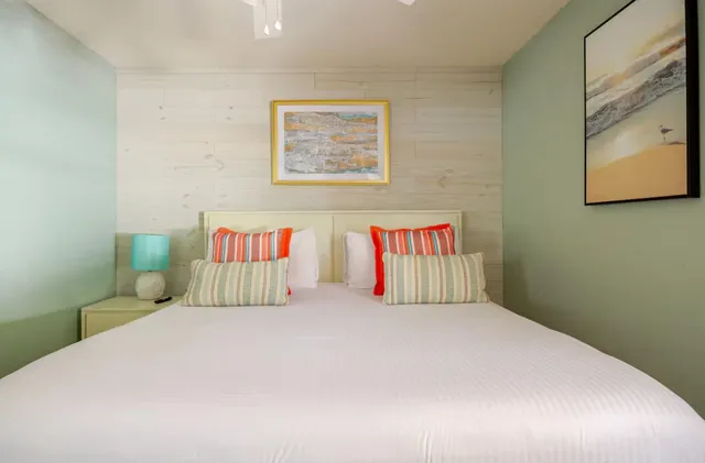 a bedroom with a bed and a painting on the wall