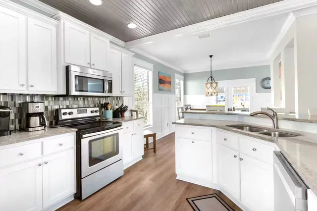 a kitchen with stainless steel appliances granite countertop a stove sink and cabinets