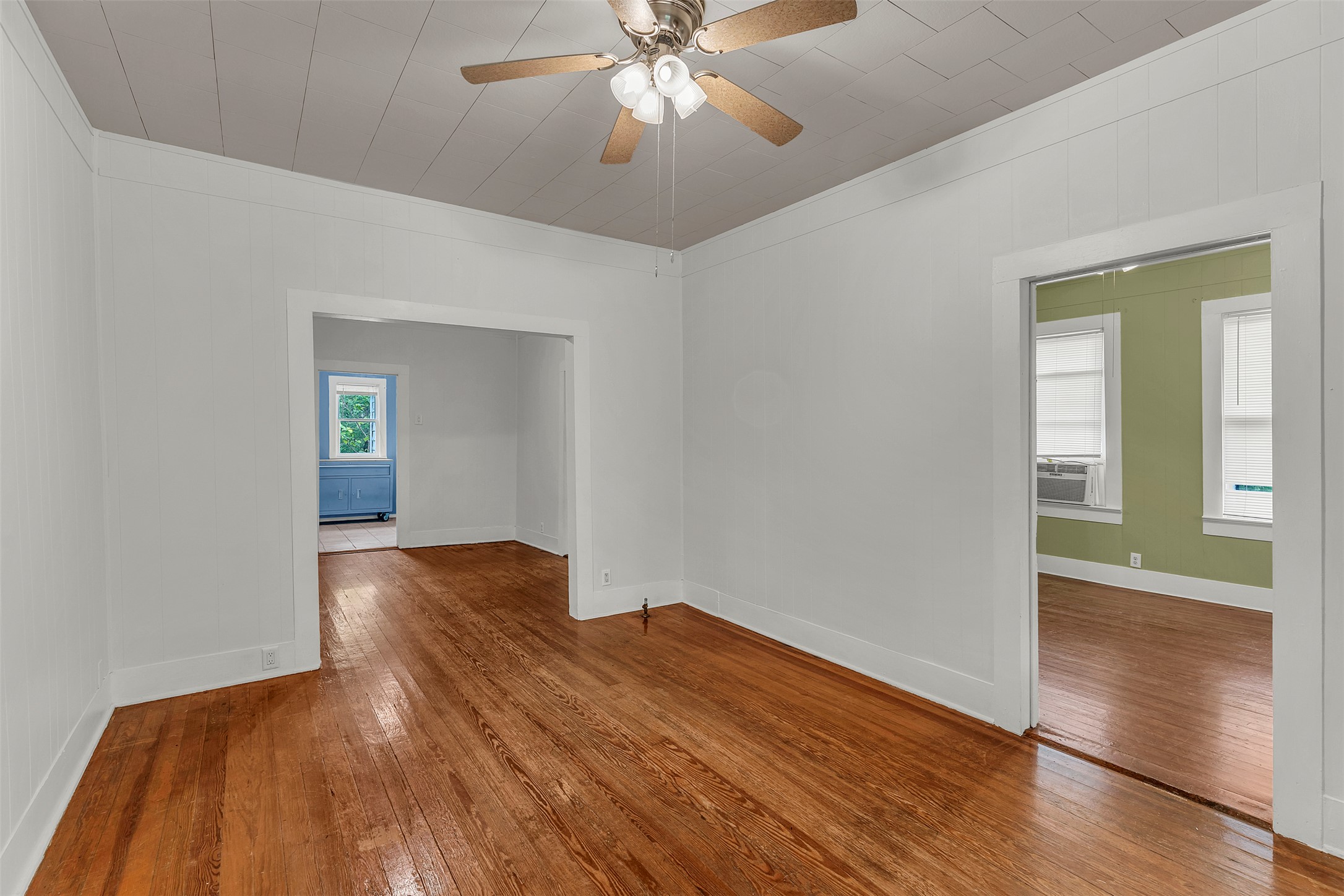1002 Washburn Street Taylor, TX 76574 - Photo 8 of 29 Living area featuring hardwood floors, white walls, and a ceiling fan