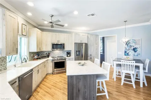 a large kitchen with kitchen island a large island in the center and stainless steel appliances
