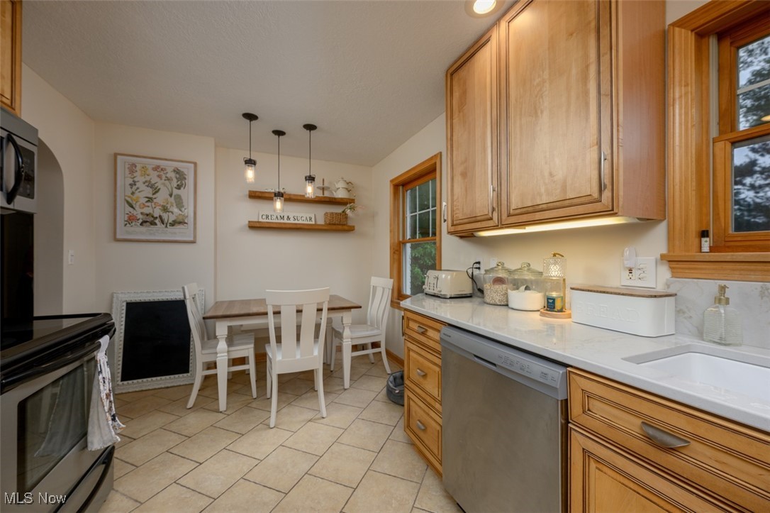 Eat-in Kitchen with quartz counters, ceramic sink and tile flooring