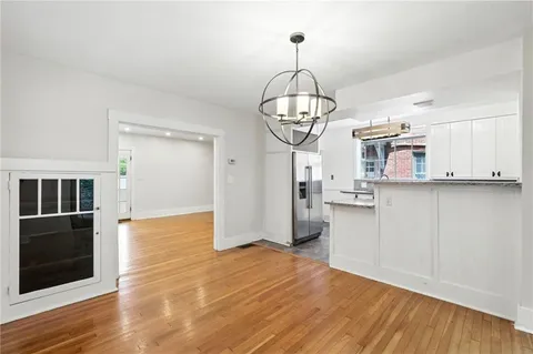 a view of a room with wooden floor and kitchen view