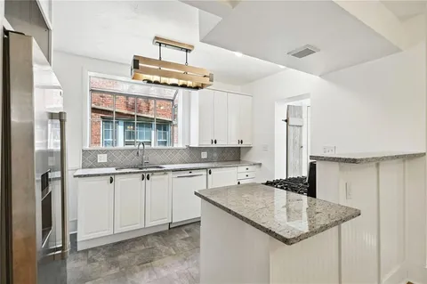 a kitchen with a sink a center island and cabinets
