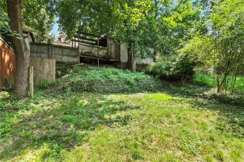 a view of a house with a yard and sitting area
