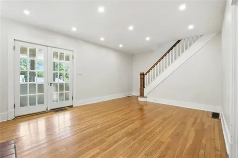 a view of an empty room with wooden floor and entryway