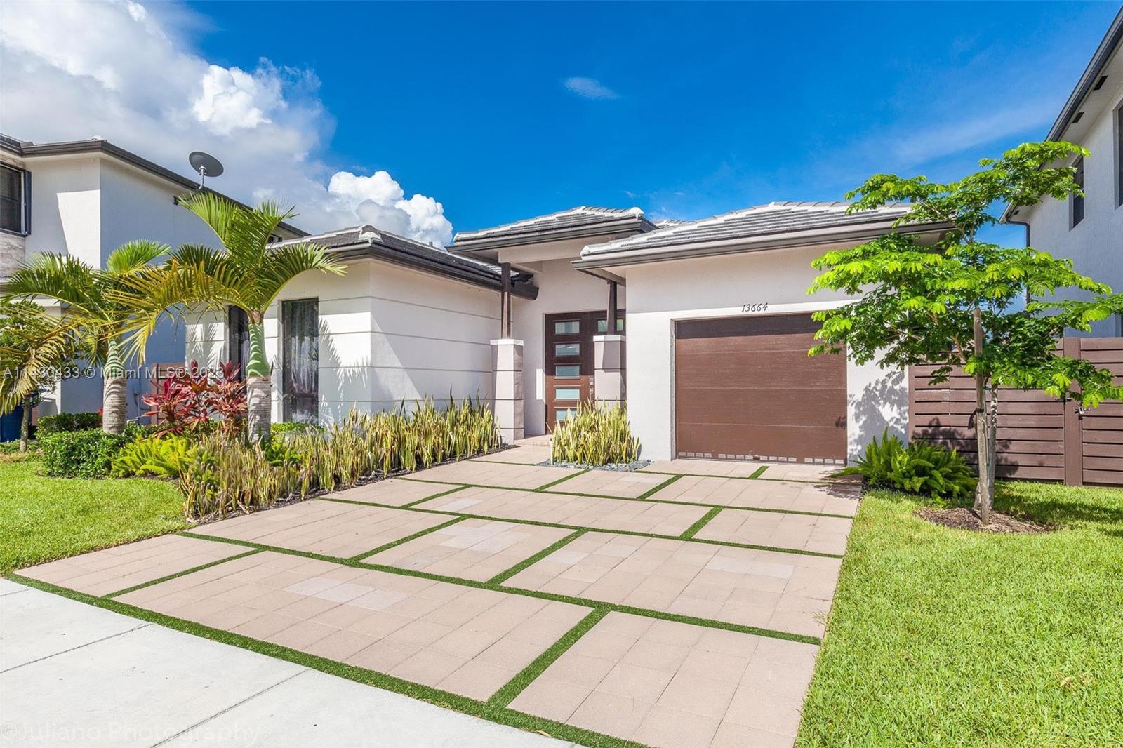 a front view of a house with a garden