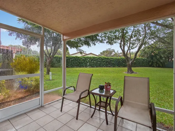 a view of chairs and table in backyard of house