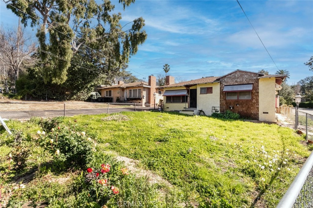 a view of a house with a big yard and potted plants
